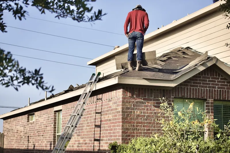 Professional roofer working on a residential roof in Lakes by the Bay